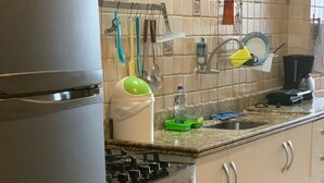 Una cocina con refrigerador, estufa, horno y salpicadero de azulejos.