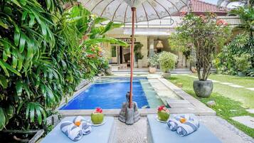 Una piscina al aire libre, tumbonas