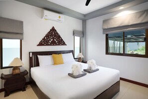 A hotel room with a large bed, two bedside tables, a wall-mounted air conditioner, and a window with a view.