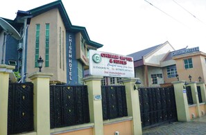 A hotel with a signboard displaying the name 'CHISAM HOTEL & SUITES' and contact information. - Emerald Hotel Annex (Port Harcourt)