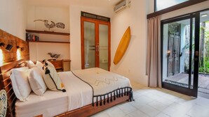 A bedroom with a wooden bed, a large window, a sliding glass door, and a surfboard leaning against the wall. - Beautiful 4 Bedroom Villa, Oberoi (Seminyak)