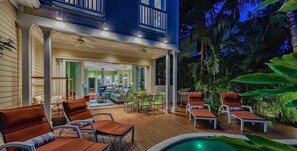 A covered outdoor area with lounge chairs and a pool, surrounded by tropical plants. - **JASMINE JEWEL @ THE ANNEX** Lush Home & Pool + Last Key White Glove Service... (Key West)