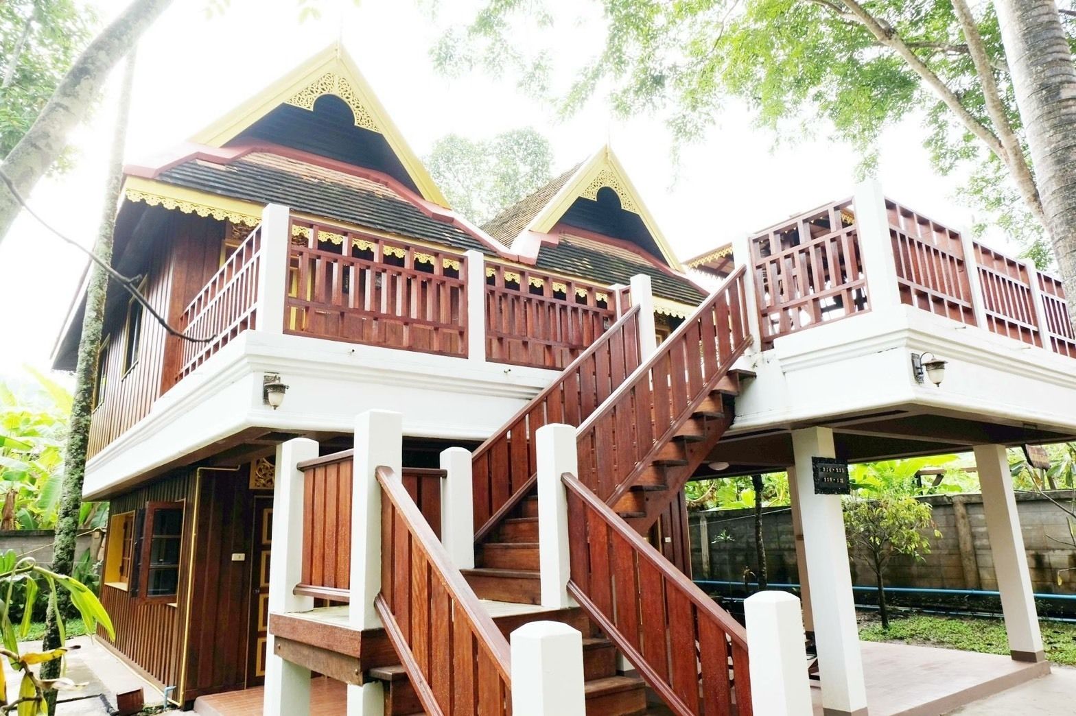 Una casa de madera tradicional con una escalera que lleva a un balcón.