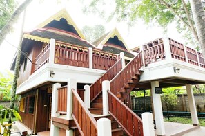 Una casa de madera tradicional con una escalera que lleva a un balcón.