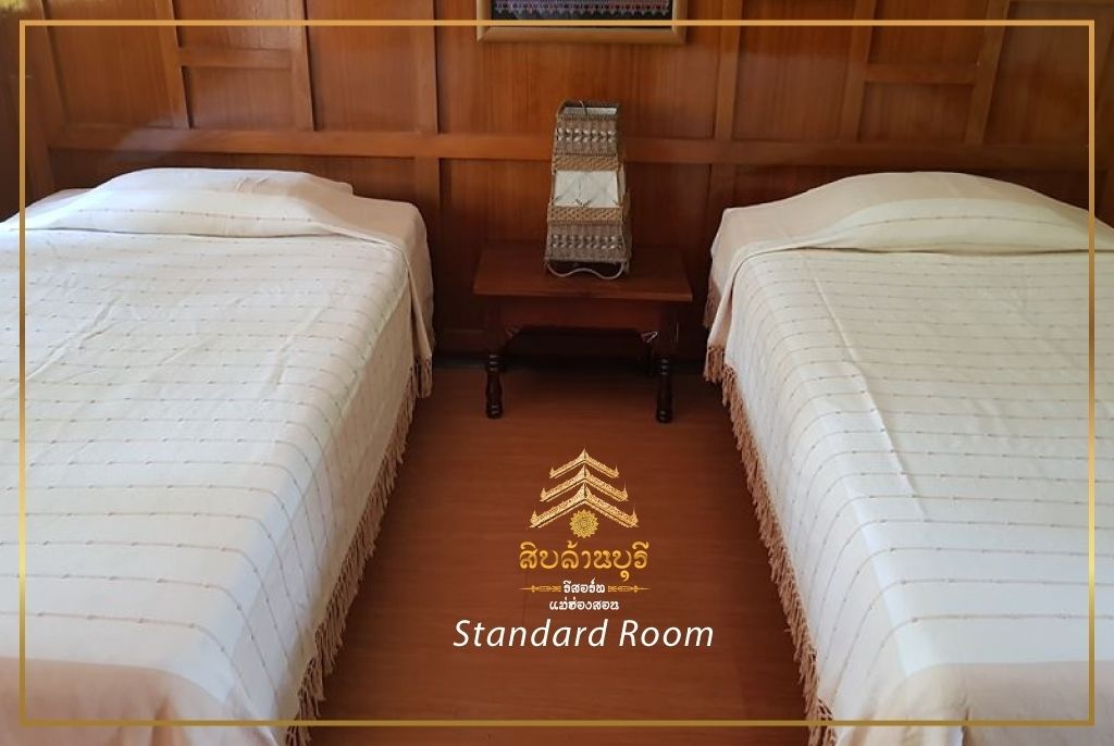 A standard room with two beds, a wooden headboard, and a small table with a woven basket.