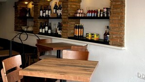 L’intérieur d’un restaurant avec des arches en briques, des tables et des chaises en bois.