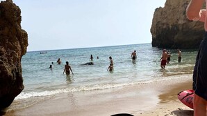 Une plage avec des kayaks et des gens dans l’eau.