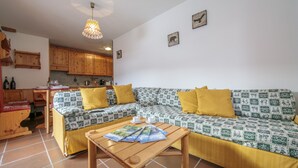 A cozy living room with a sofa set, a coffee table, and a kitchen area in the background. - Martina Ski in - Ski out 50m, Livigno, Italy (Livigno)