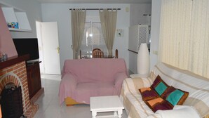 A living room with a sofa, a small table, a television, and a fireplace. - House 4 Mar y Arena. Villa with private pool and all possible extras. (Barbate Cadiz)