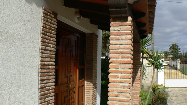 A brick exterior with a wooden door and a small potted plant. - House 4 Mar y Arena. Villa with private pool and all possible extras. (Barbate Cadiz)