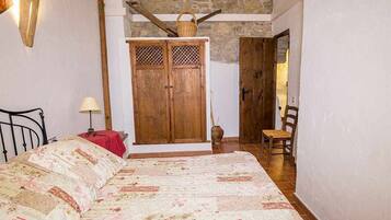 Un dormitorio con una cama grande, un armario de madera y una silla.