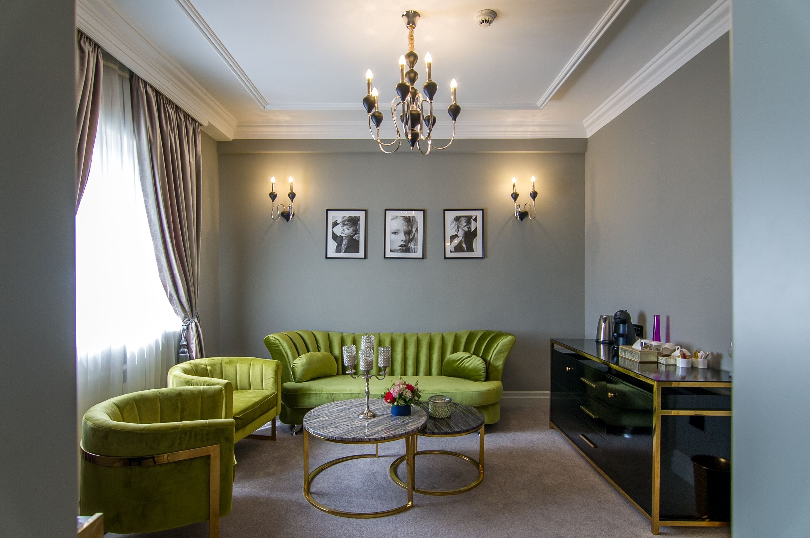 A living room with a green sofa, two armchairs, a coffee table, and a TV stand.