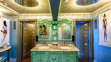 A bathroom with two sinks, a vanity with drawers, and a mirror above the sinks.