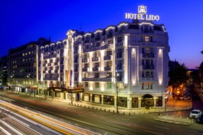 A multi-story hotel with a prominent 'HOTEL LIDO' sign, featuring balconies and a row of shops at the ground level. - Lido by Phoenicia (Bucharest)