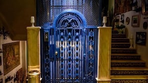 A grand entrance with a blue gate, a marble floor with geometric patterns, and a staircase leading upwards. - Lido by Phoenicia (Bucharest)