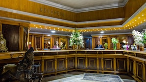 A grand lobby with a reception desk, a horse statue, and a chandelier. - Lido by Phoenicia (Bucharest)