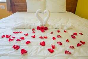 A bed with white bedding and a heart-shaped towel arrangement. - Seika Hotel (Ho Chi Minh City)