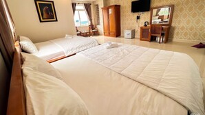 A hotel room with two beds, a TV, a wardrobe, and a desk with a chair. - Seika Hotel (Ho Chi Minh City)