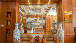 A Seika Hotel lobby with traditional decor, including wooden furniture, large vases, and clocks displaying different cities. - Seika Hotel (Ho Chi Minh City)