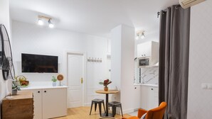 A modern, well-lit room with a bed, a desk, and a dining area. - Casa Armonía, charming apartment in the centre (Málaga)