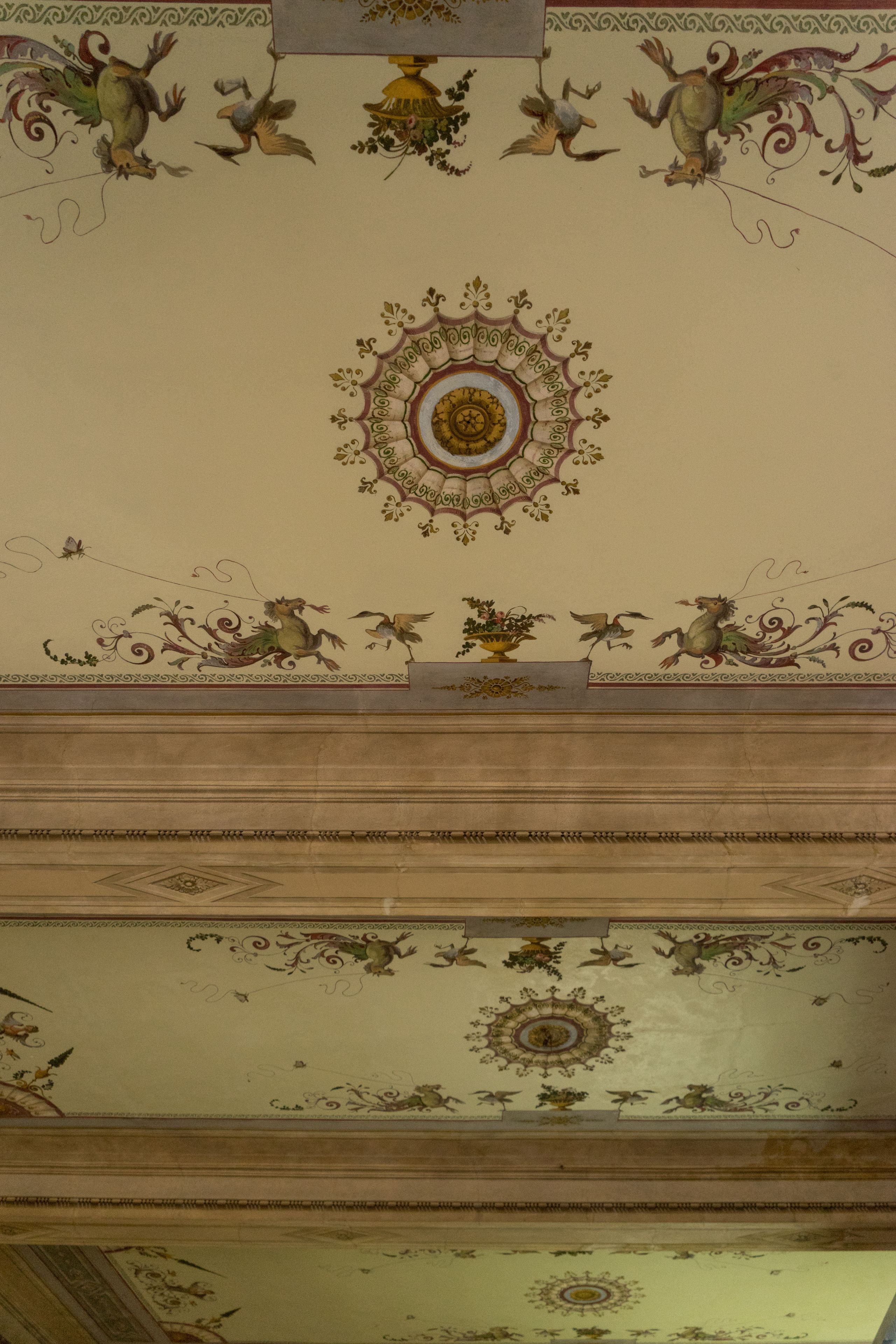 Un plafond orné de fresques et surmonté d’un médaillon central.
