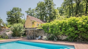 A rectangular swimming pool with a wooden deck surrounding it.