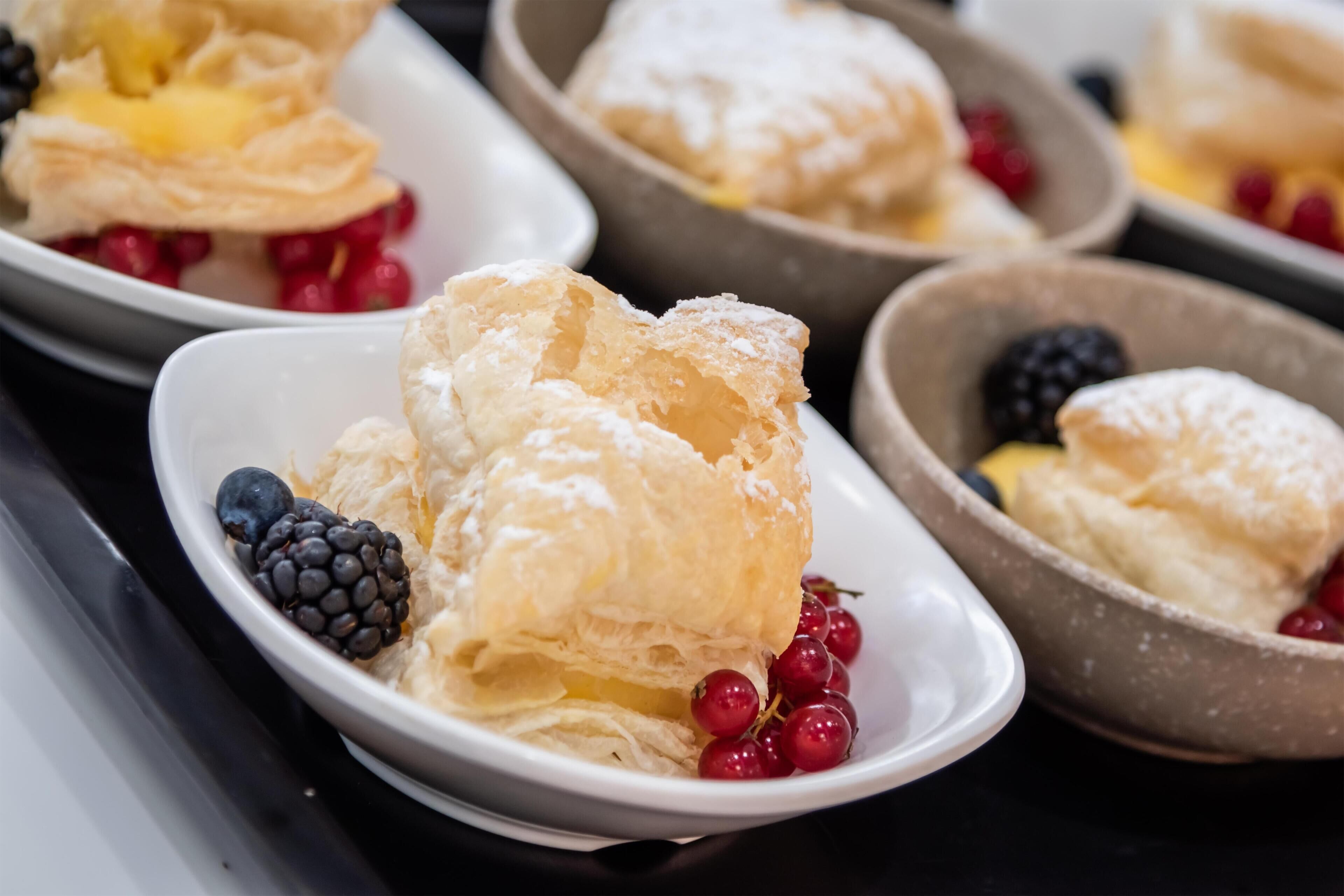 A selection of pastries with berries on a tray.