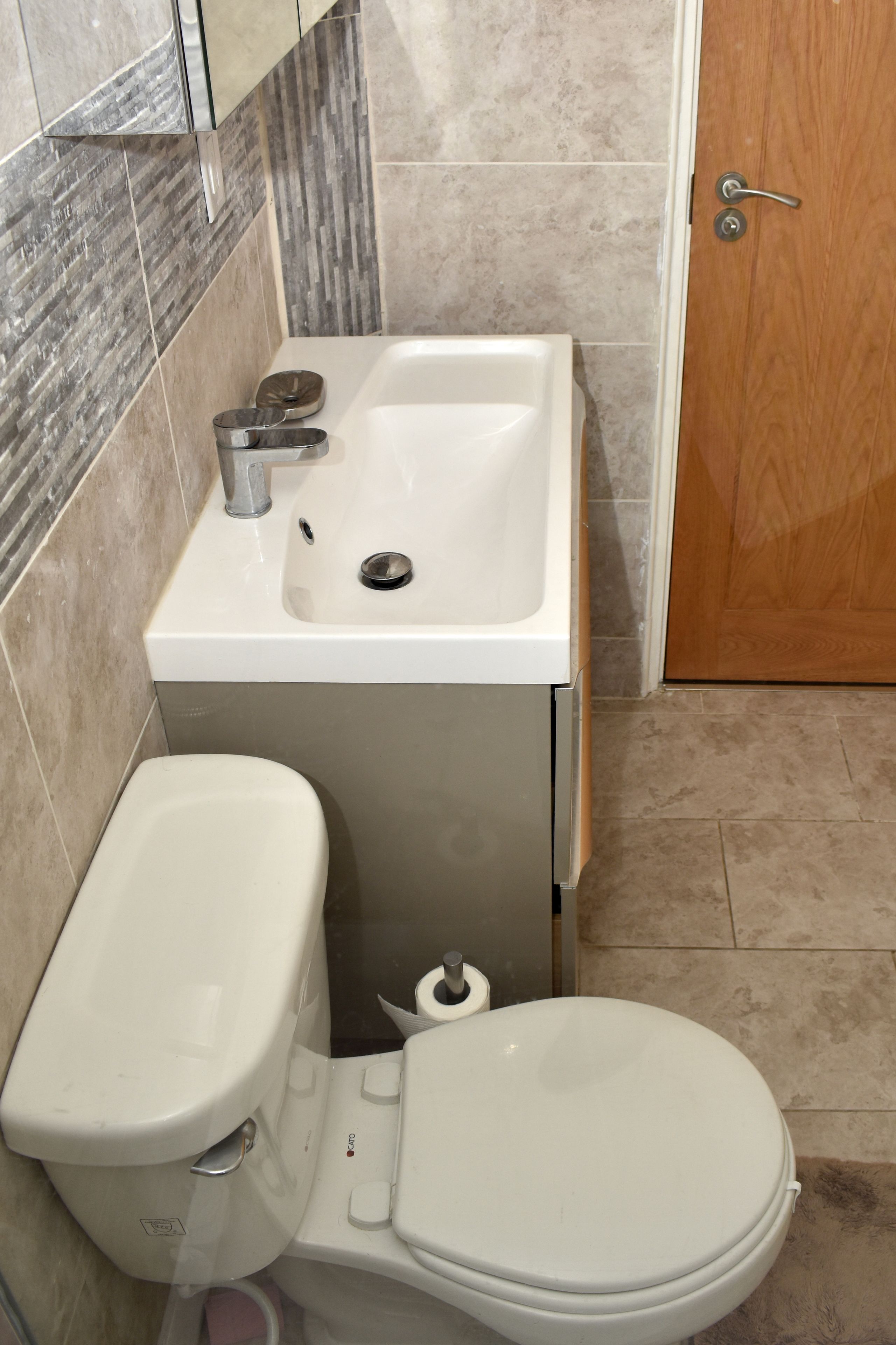 Une salle de bain avec des toilettes, un lavabo et une douche.