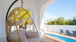A hanging chair by a pool with a view of the sky and trees. - House in quiet and green surrounding where you can disconnect and enjoy family (La Nucia)