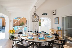 A round dining table set with plates, cutlery, and glasses, surrounded by black chairs. - House in quiet and green surrounding where you can disconnect and enjoy family (La Nucia)