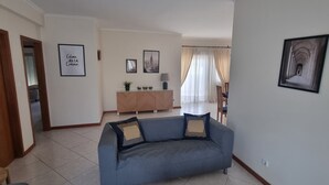Un saló amb un sofà, un armari i un quadre encimbellat a la paret.