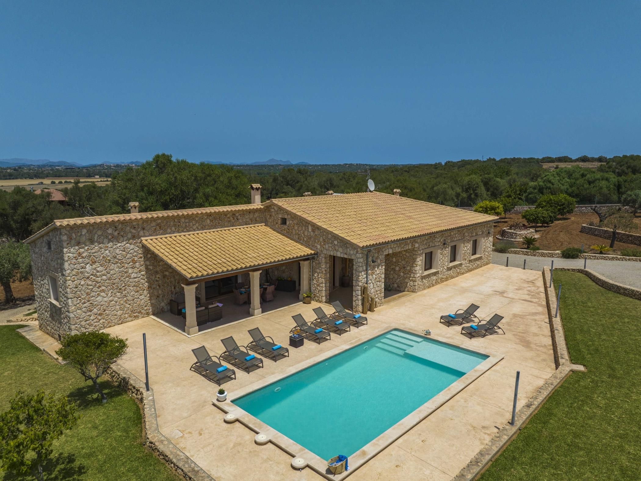 A stone building with a pool and outdoor seating.