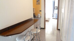 A kitchen with a wooden countertop, two bar stools, and a coffee machine. - Rabadan Bed and Breakfast (Turin)