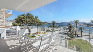 Ein Balkon mit Frühstückstisch, mit Blick auf eine Marina mit Booten und einem klaren Himmel.