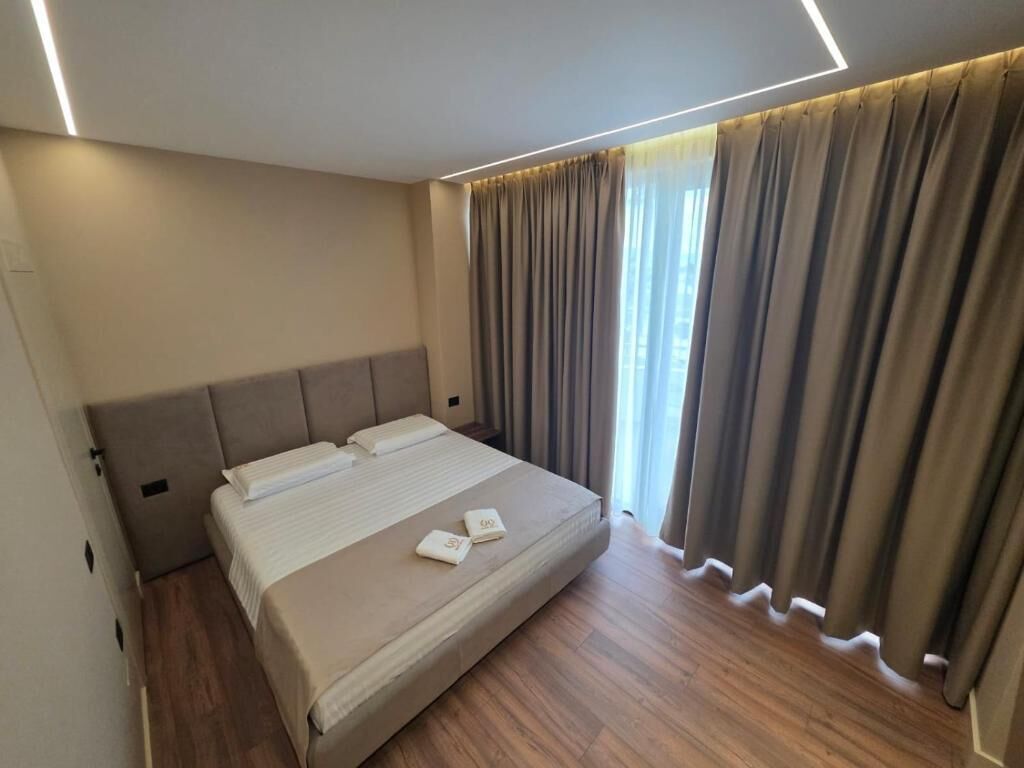 Une chambre d’hôtel avec un lit, des rideaux et une vue sur l’extérieur.