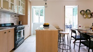 A modern kitchen with a central island, wooden cabinets, and a built-in oven.
