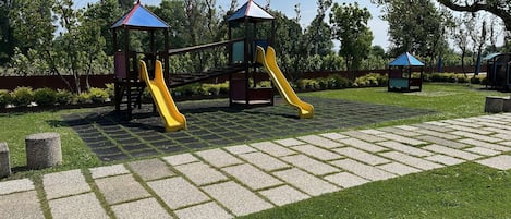 A playground with two slides and a small shelter.