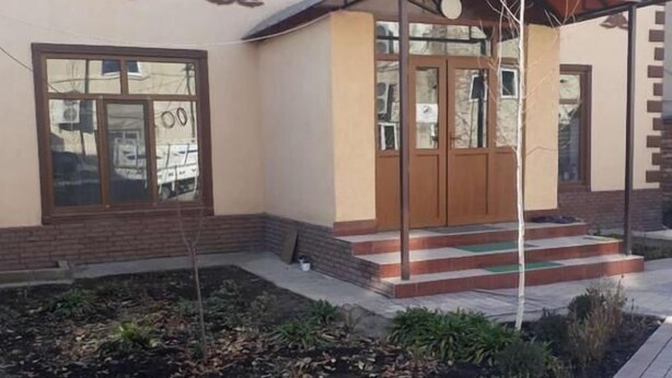 Un bâtiment doté d’une entrée abritée, de fondations en briques et d’un jardin aménagé.
