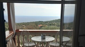 Ein Balkon mit Tisch und Stühlen, Meerblick und ein Fliesenboden.