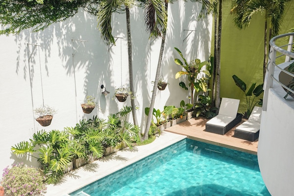 Una piscina al aire libre, sillones reclinables de piscina