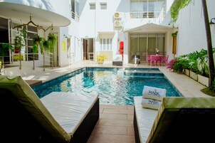 Una piscina al aire libre, sillones reclinables de piscina