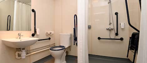 A bathroom with a sink, toilet, shower, and grab bars.