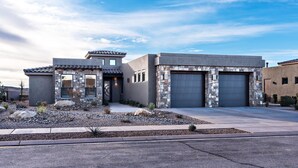 A modern two-story house with a stone facade, a garage, and a landscaped front yard. - Zane's Place (St. George)