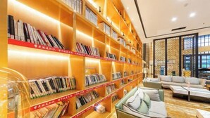 A library with bookshelves and seating areas. - Times Holiday Hotel (Liupanshui)