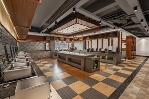 Una cocina moderna con una isla central, varios lavamanos y un suelo con estampado de cuadros.