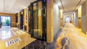 A hotel corridor with a marble floor, glass doors, and a long hallway. - Times Holiday Hotel (Liupanshui)