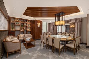 A modern dining area with a round table, chairs, and a coffee table. - Times Holiday Hotel (Liupanshui)