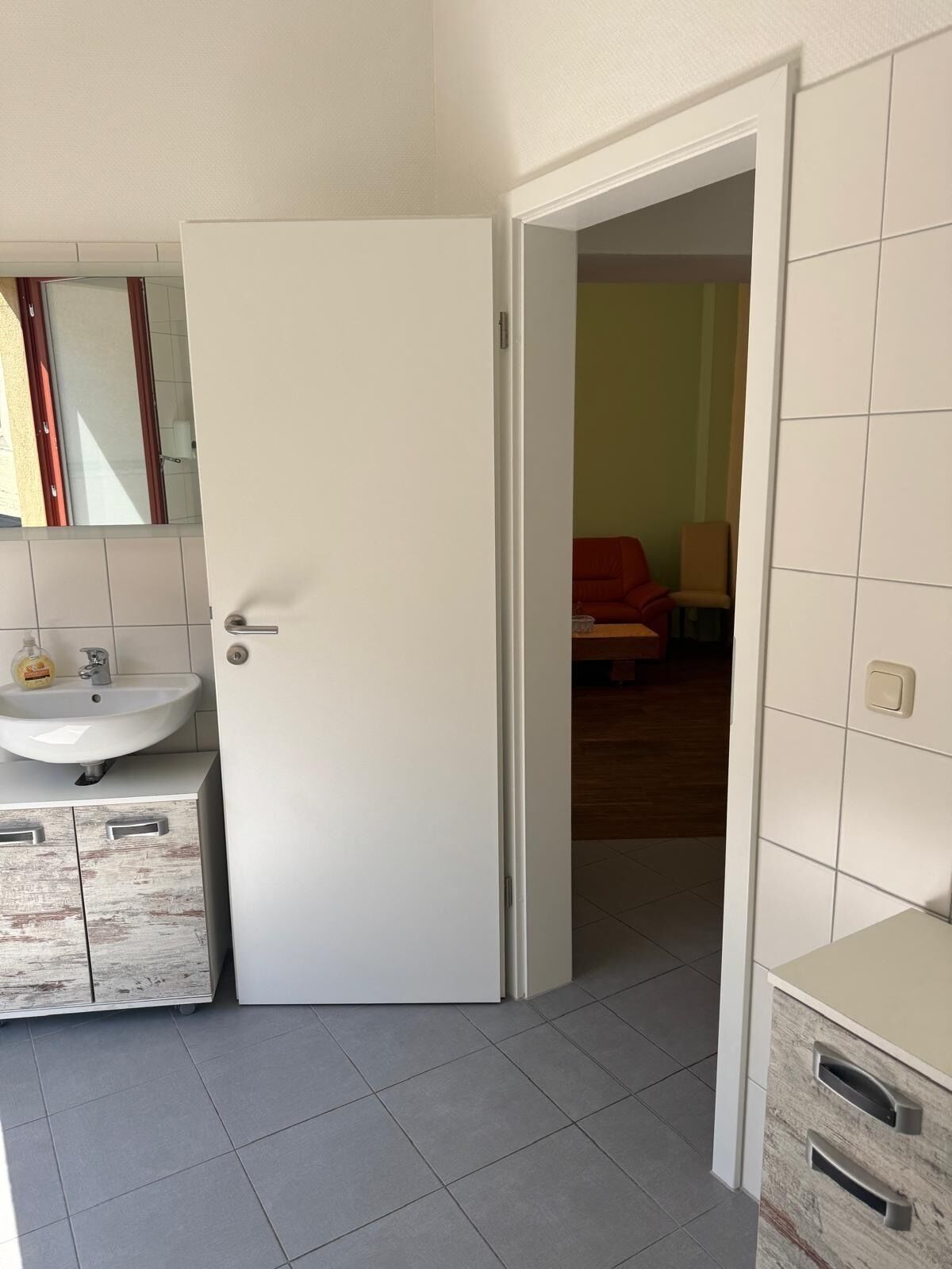 Ein Badezimmer mit Waschbecken, Spiegel und Schränken.