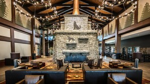 A lobby with a stone fireplace, wooden beams, and a chandelier. - Great Wolf Lodge Arizona (Scottsdale)