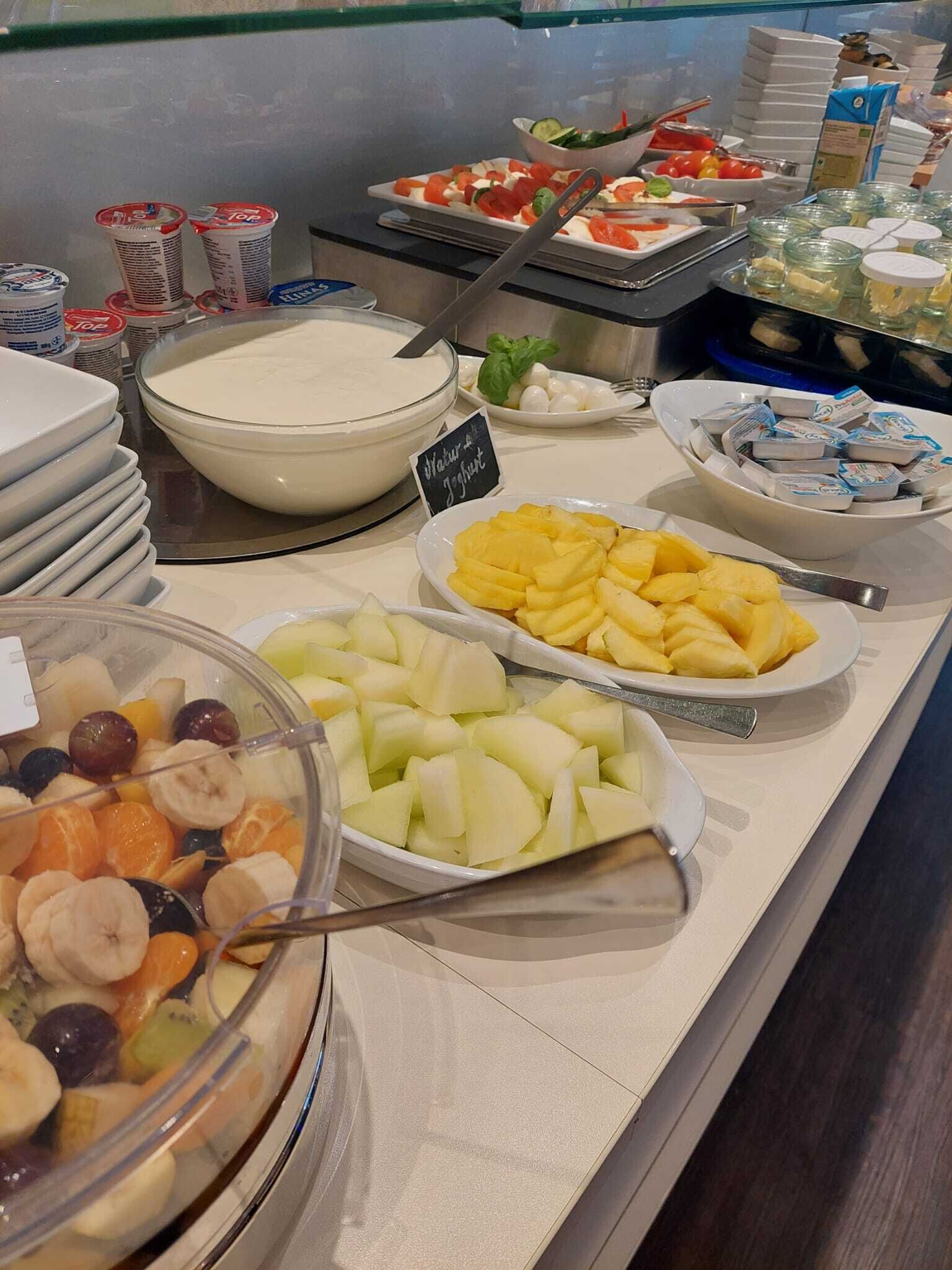 A buffet with various fruits, yogurt, and other food items.